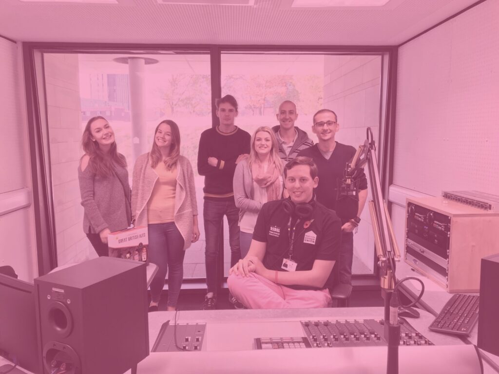 Group team photo at rebel studio university of essex apprentice challenge pink image overlay