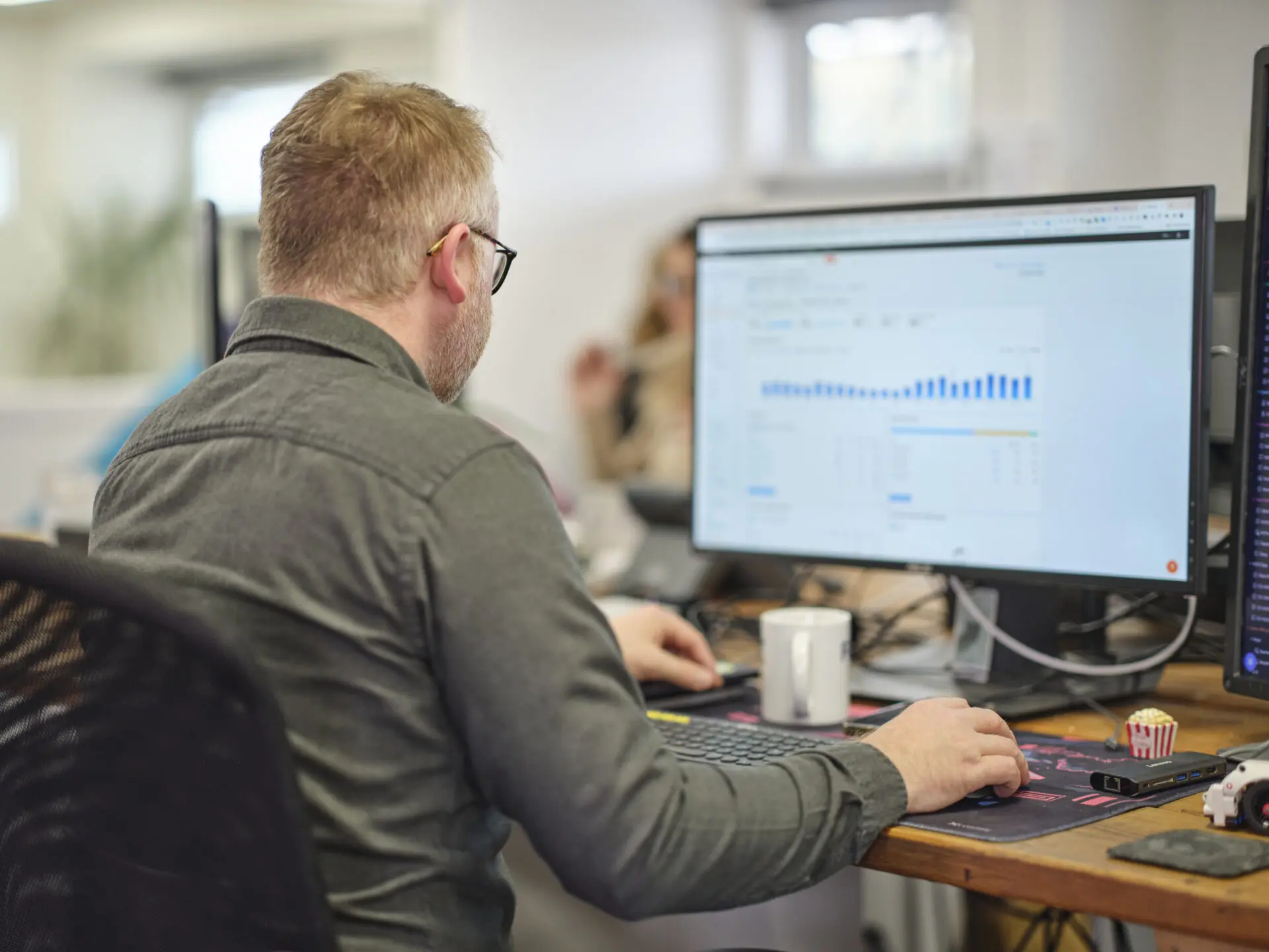 Full colour office shot sam at his desk looking at google analytics