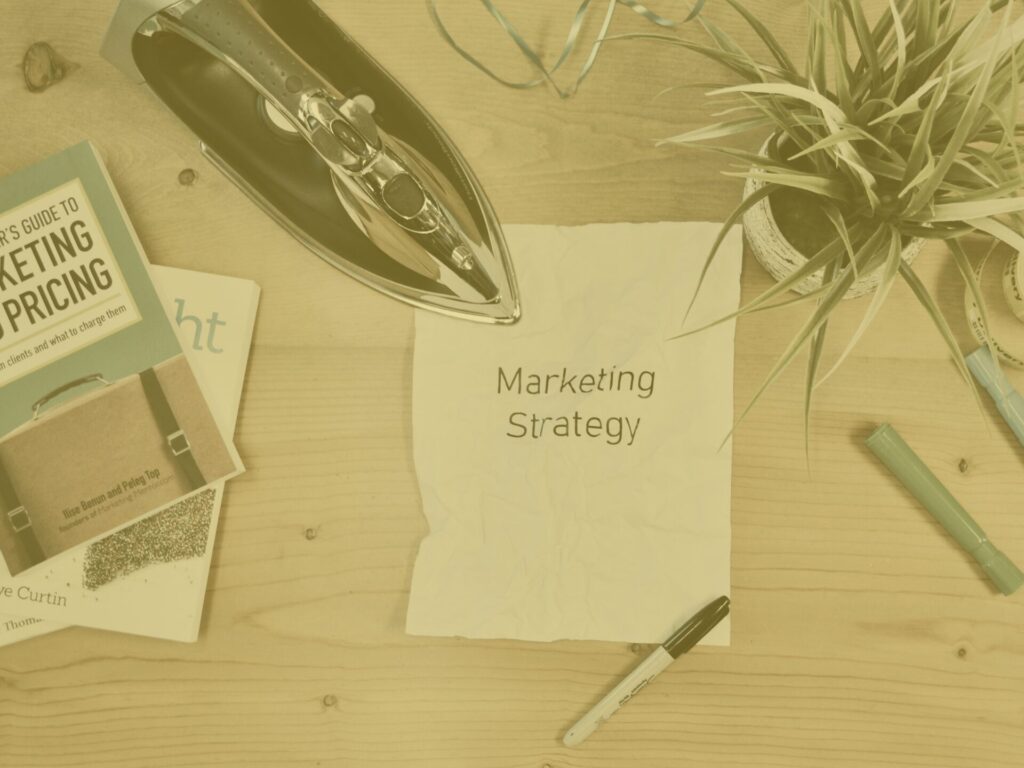 Yellow desk flatlay with marketing strategy written on a piece of paper