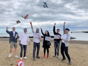 Full colour footprint academy group throwing graduation hats on clacton beach