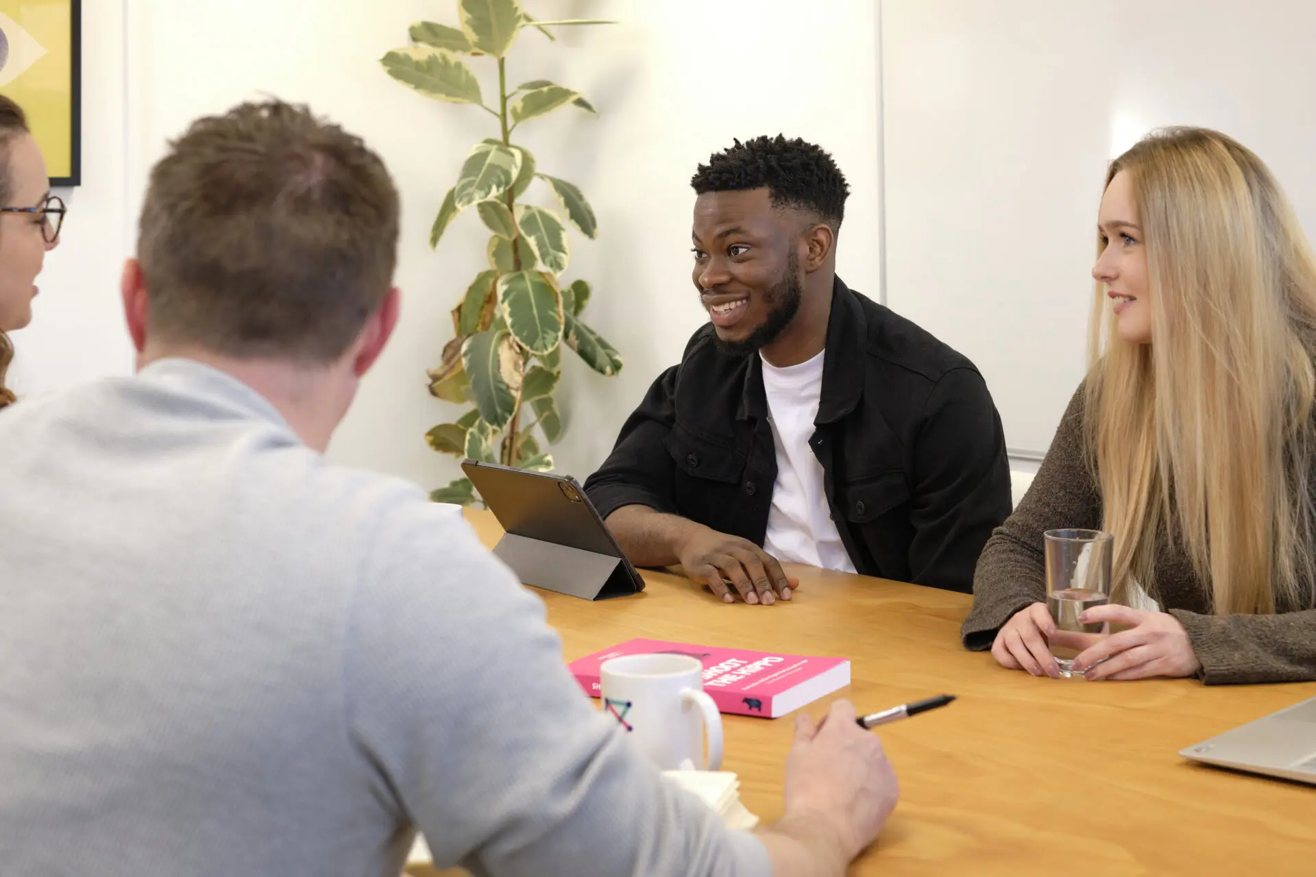 Full colour office shot - four people in meeting room one - Bailey, Emeke, Carl, Charlotte